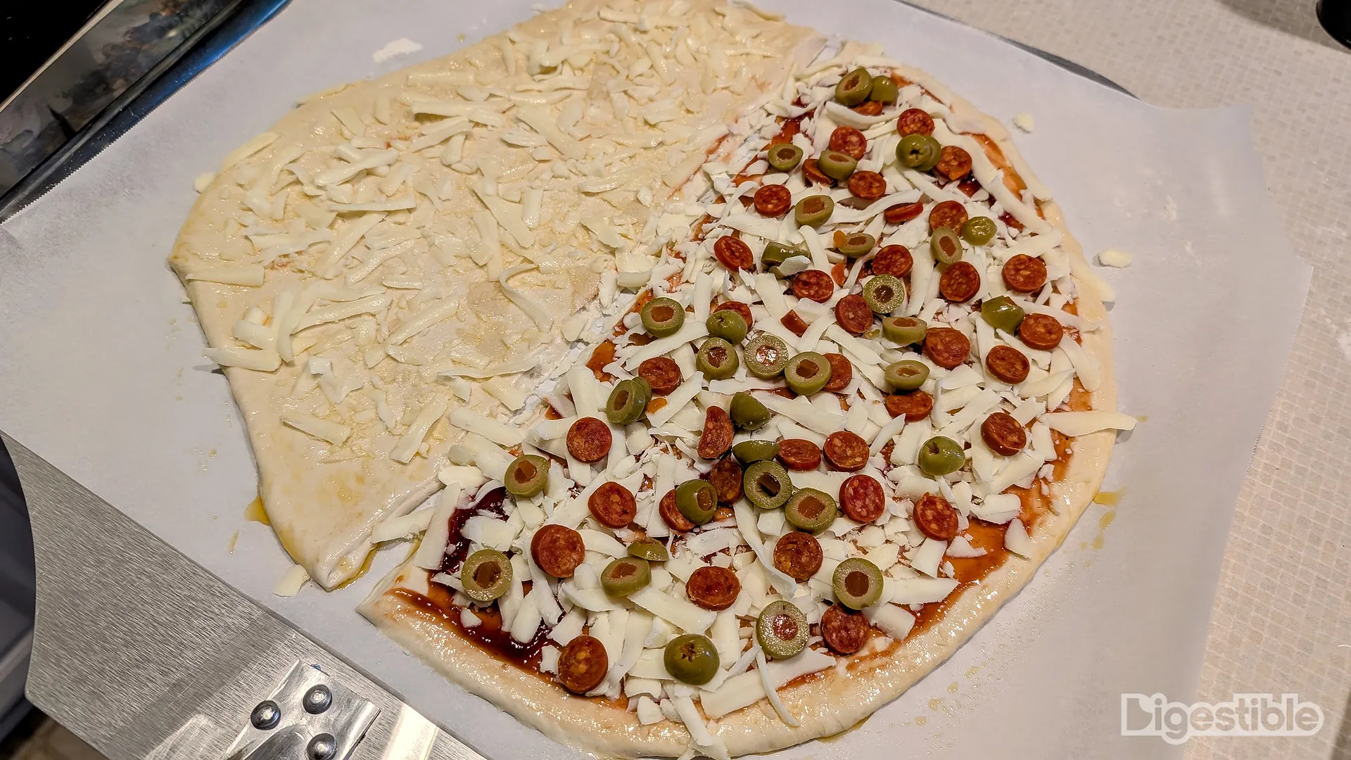 Uncooked pizza with only cheese on one half.