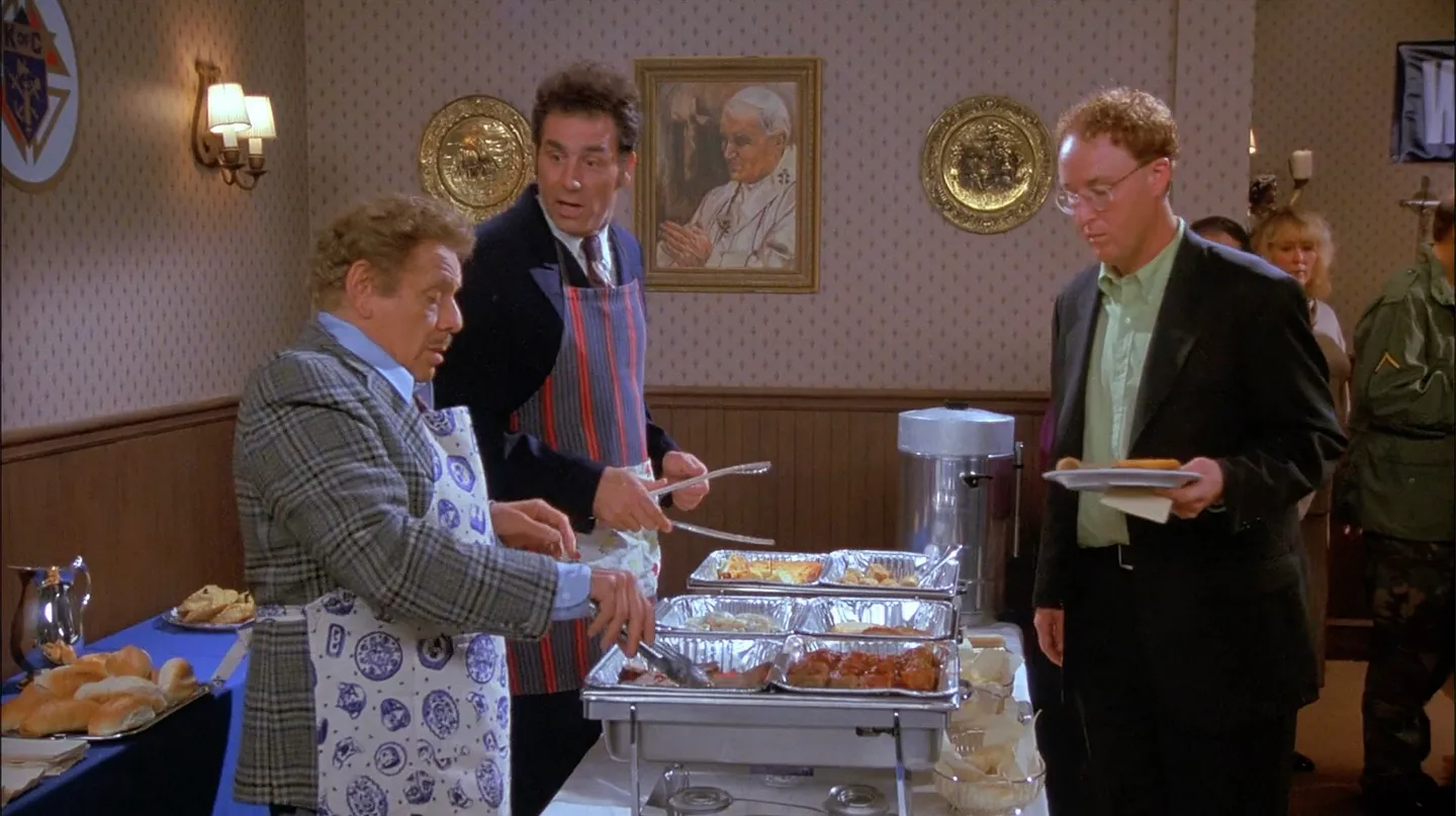 Frank Costanza and Kramer serving food.