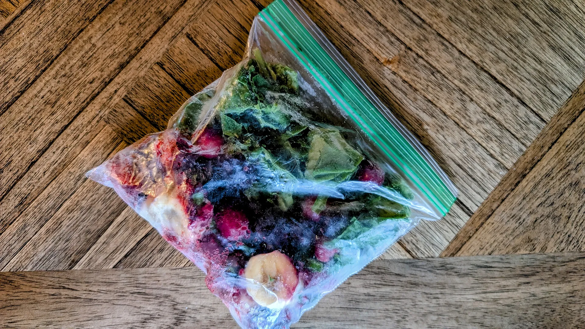 Frozen fruit and spinach in a zip-top bag.