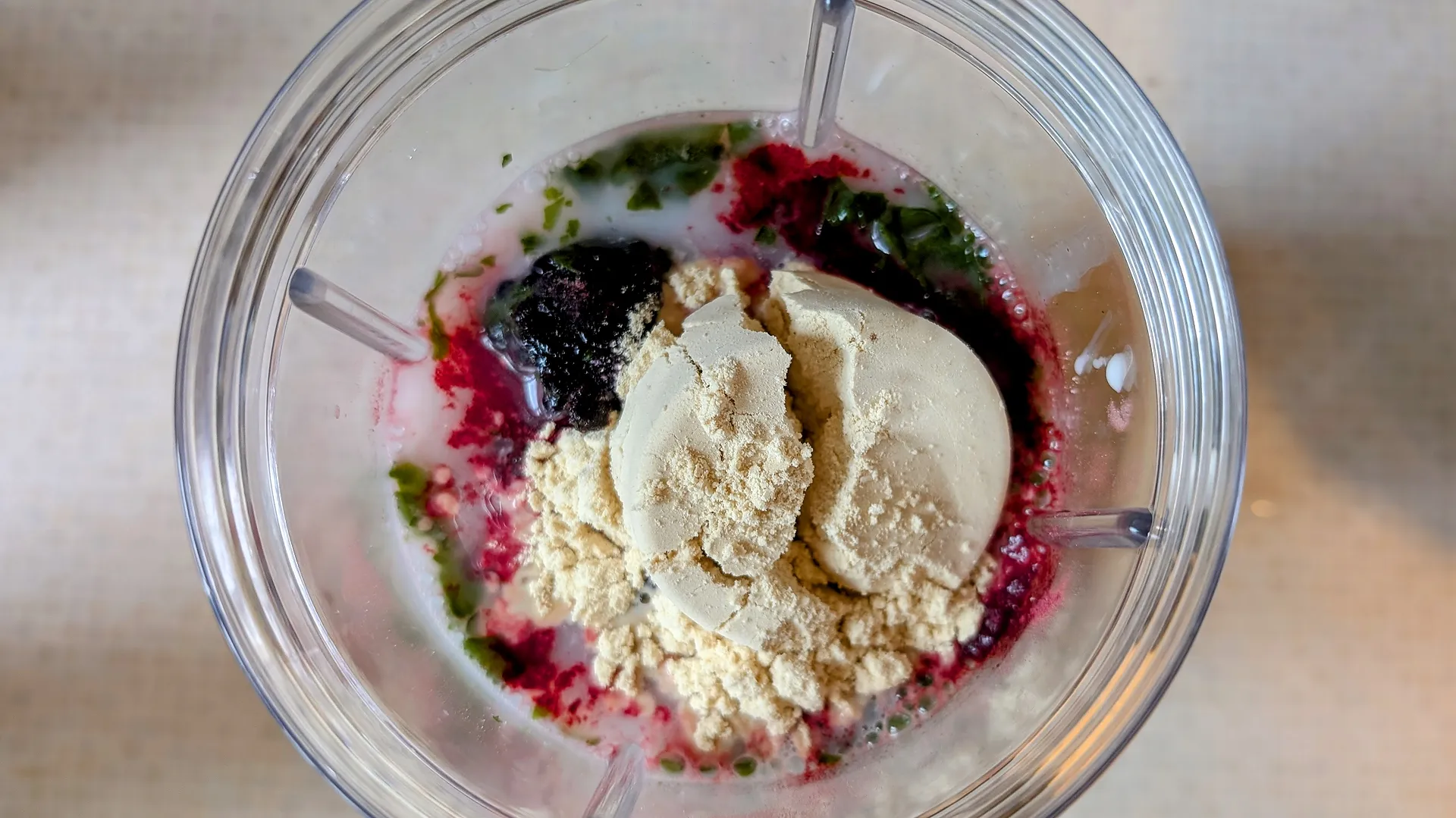 Fruit, spinach, and protein powder in a blender bottle.