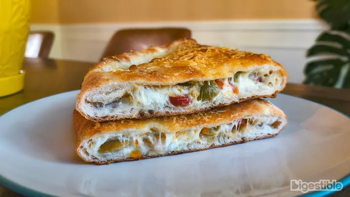 A calzone cut open and stacked on itself.